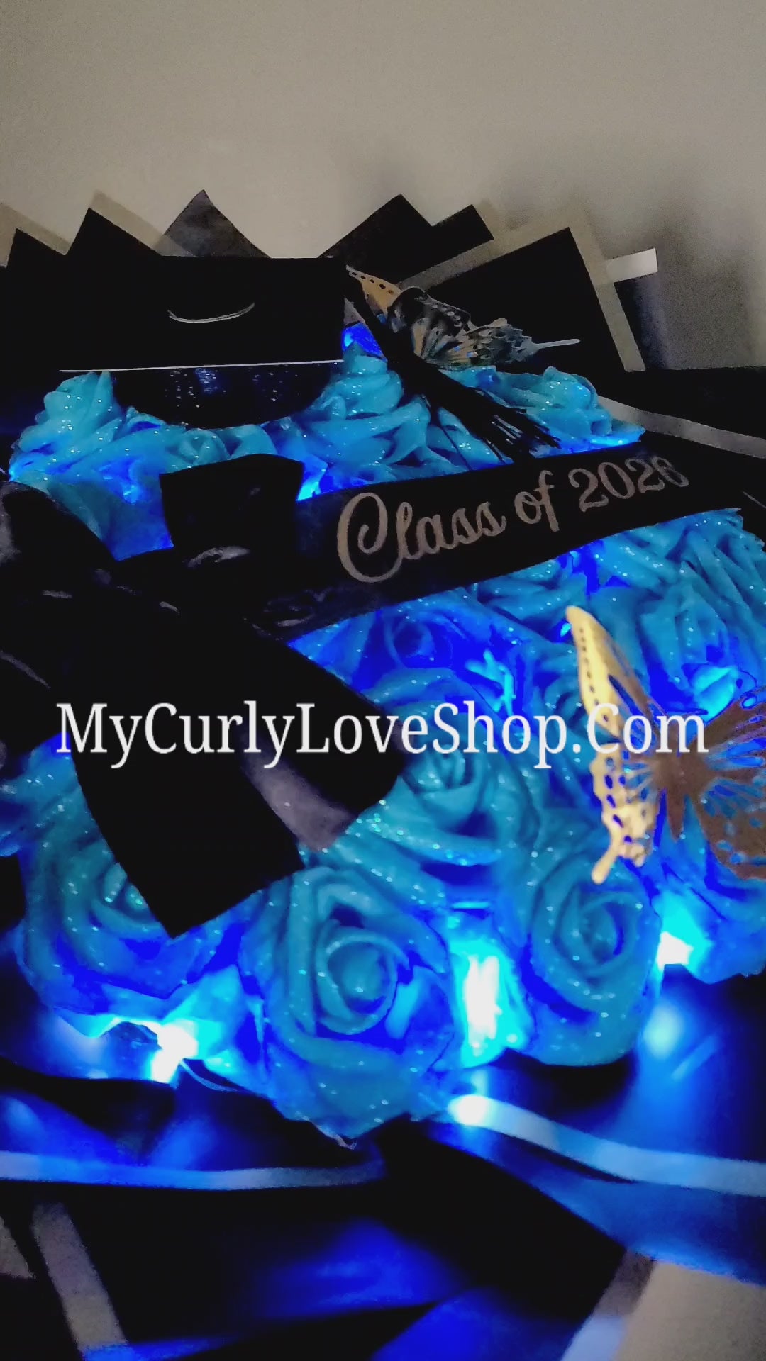 Graduation Glitter Roses Bouquet. Graduation Cap and 2 gold butterflies Included. Banner and Lights are additional.
