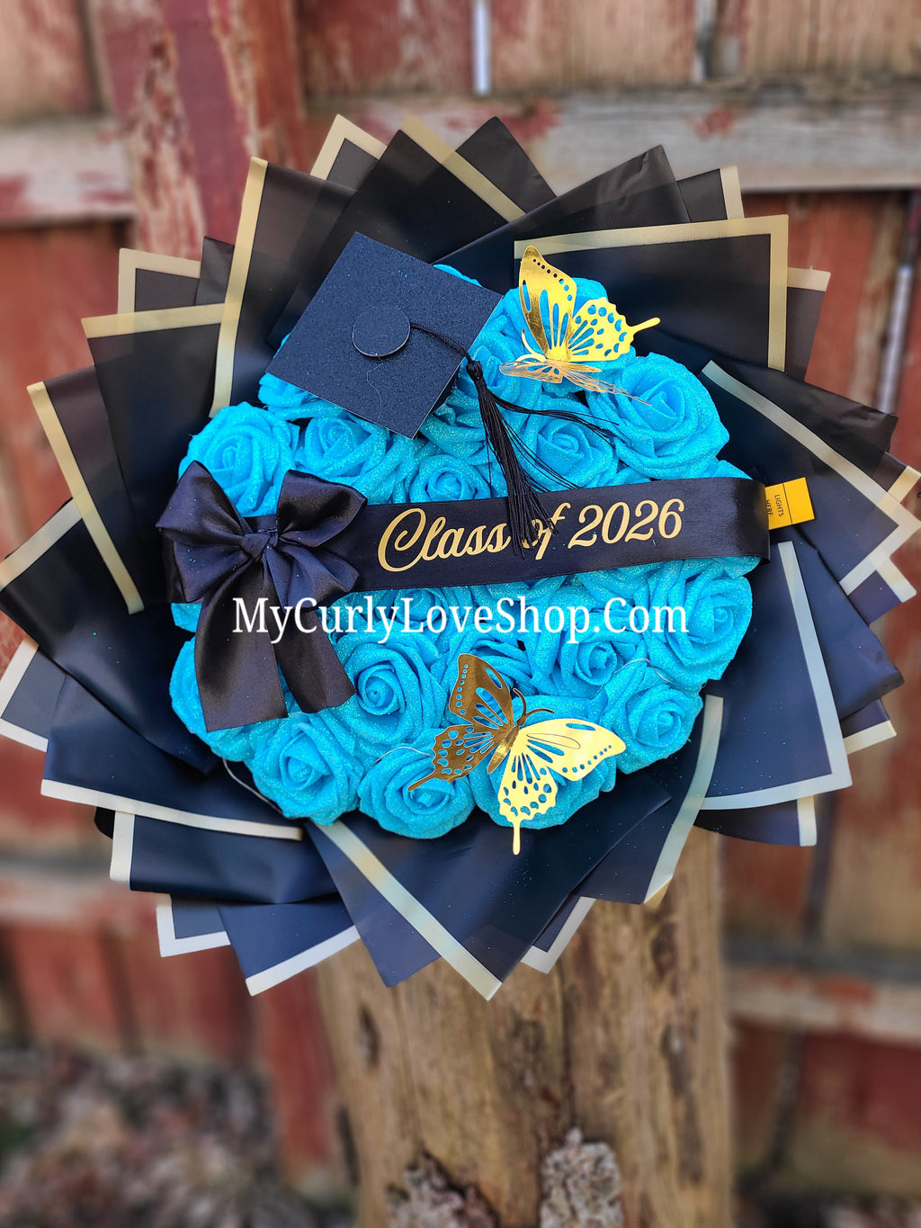 Graduation Glitter Roses Bouquet. Graduation Cap and 2 gold butterflies Included. Banner and Lights are additional.
