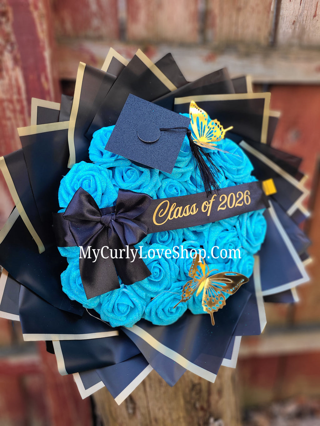 Graduation Glitter Roses Bouquet. Graduation Cap and 2 gold butterflies Included. Banner and Lights are additional.