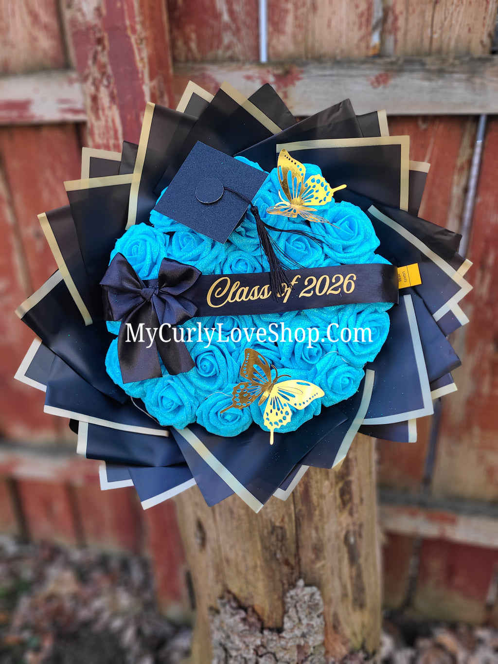Graduation Glitter Roses Bouquet. Graduation Cap and 2 gold butterflies Included. Banner and Lights are additional.