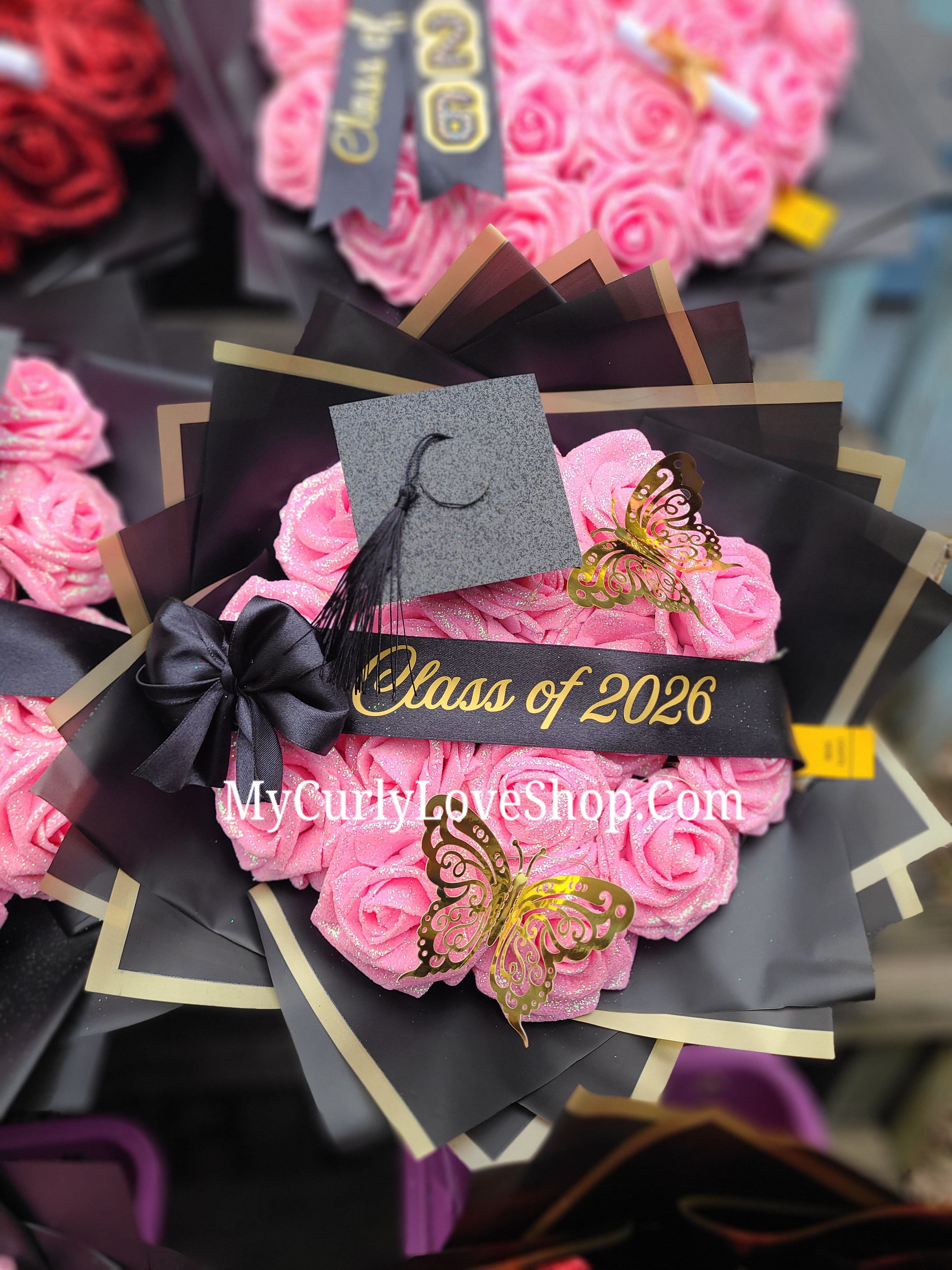 Graduation Glitter Roses Bouquet. Graduation Cap and 2 gold butterflies Included. Banner and Lights are additional.