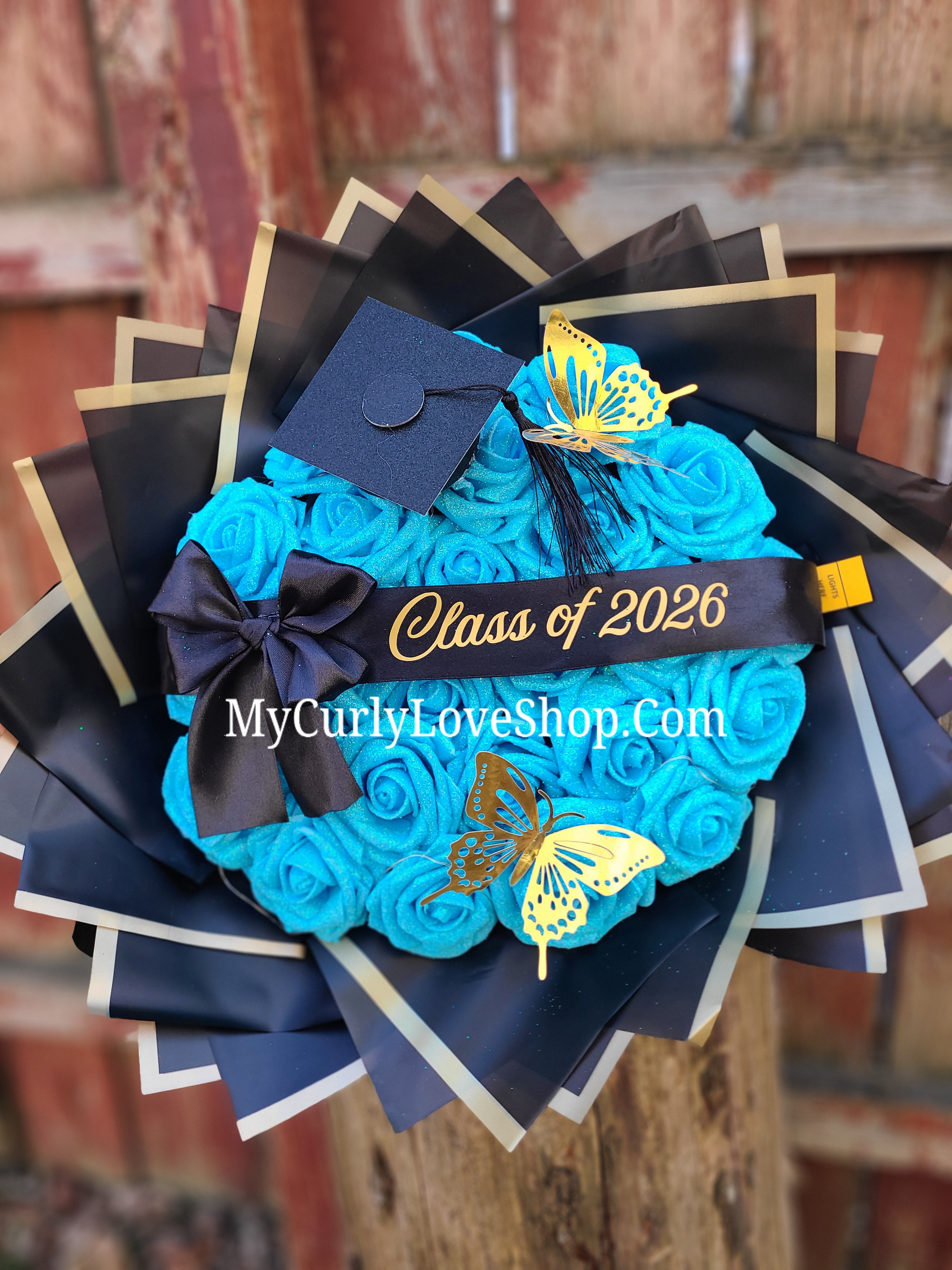 Graduation Glitter Roses Bouquet. Graduation Cap and 2 gold butterflies Included. Banner and Lights are additional.